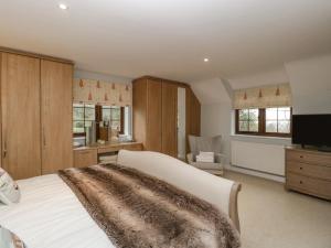 a bedroom with a white bed with a blanket on it at Sundowner Cottage in Axminster