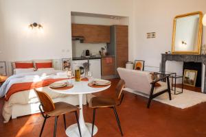 sypialnia z łóżkiem, stołem i krzesłami w obiekcie Superbe appartement rénové et cosy à 10mn de Saint-Rémy de Provence w mieście Noves