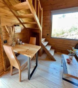 Habitación de madera con mesa y sillas en una cabaña en Mountain Eco Shelter 6, en Funchal