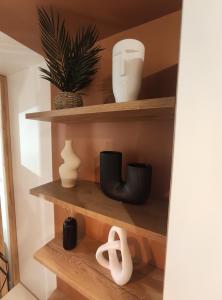 a shelf with pots and vases on it at Calme et cosy, proche hyper centre de Nantes in Nantes