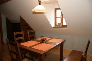 drewniany stół i krzesła w pokoju z sufitem w obiekcie Apartmaji Žolnir w mieście Kostanjevica na Krki