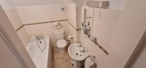 a small bathroom with a toilet and a sink at Parterre Holiday Apartments in Sandown +79 photos