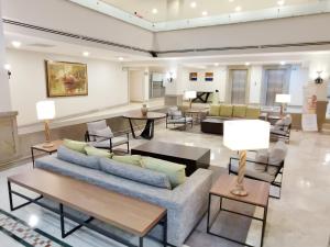 a living room with a couch and tables and chairs at Holiday Inn Reynosa Zona Dorada by IHG in Reynosa