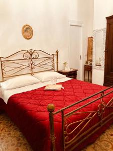 um quarto com uma cama grande e um cobertor vermelho em LA CONCHIGLIA em Marsala
