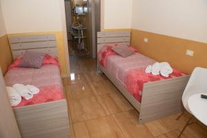 Duas camas num pequeno quarto com um lavatório em Appartamenti S Onofrio Rho em Rho