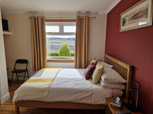 a bedroom with a large bed with a window at Skeabostview B&B in Skeabost