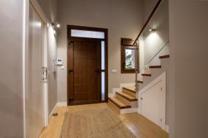 a hallway with a wooden door and stairs at Casa Rural La Nava de Tizneros in Tizneros