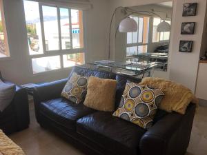 uma sala de estar com um sofá de couro preto com almofadas em 1B Barabas em Mijas Costa