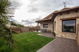 einen Hinterhof mit einem Steinhaus mit einer Terrasse in der Unterkunft Casa Rural La Nava de Tizneros in Tizneros