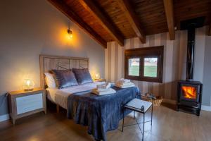 1 dormitorio con 1 cama y estufa de leña en Casa Rural La Nava de Tizneros, en Tizneros