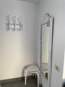uno specchio e uno sgabello bianco in una stanza di Apartamento Ilusión a Corralejo