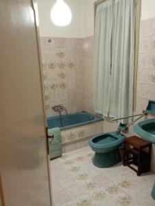 a bathroom with a blue toilet and a tub at Casa San Carlo Affittacamere Foligno in Foligno