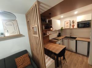 a small kitchen with a wooden table in a room at Calme et cosy, proche hyper centre de Nantes in Nantes