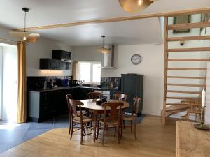 een keuken en eetkamer met een tafel en stoelen bij Charmante Maison de Campagne en Pierres et Bois in Sartilly