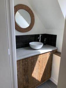 a bathroom with a sink and a mirror at Charmante Maison de Campagne en Pierres et Bois in Sartilly