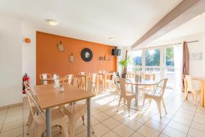 uma sala de jantar com mesas e cadeiras em Appart'City Classic Aix-en-Provence - La Duranne em Aix-en-Provence