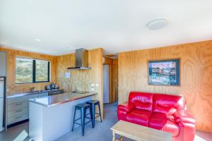 a living room with a red couch in a kitchen at The Red Nest - Lake Tekapo in Lake Tekapo