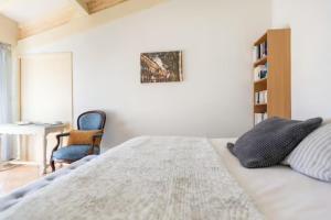 Schlafzimmer mit einem Bett, einem Schreibtisch und einem Stuhl in der Unterkunft La Chambre Verte in Cazères