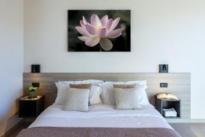 a bedroom with a large bed with a pink flower on the wall at Chiabot Langhe in Roddino