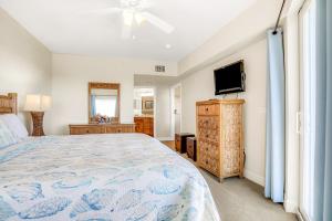 a bedroom with a bed and a flat screen tv at Oceanwalk 17-406 in New Smyrna Beach