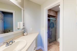 uma casa de banho com um lavatório, um espelho e um chuveiro em Sunset Harbor Palms 2-106 em Navarre