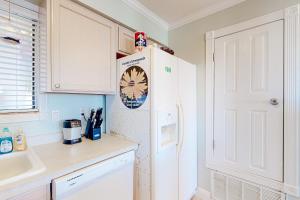 uma cozinha com um frigorífico branco com um relógio em Sunset Harbor Palms 2-106 em Navarre