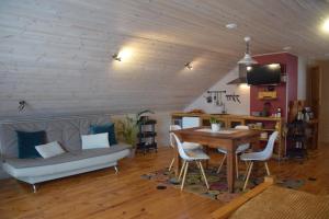 a living room with a table and a couch at Čučumuiža in Ķimale