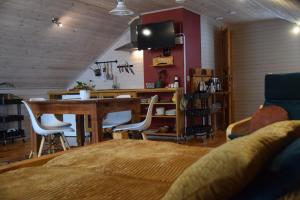 a living room with a table and a dining room at Čučumuiža in Ķimale