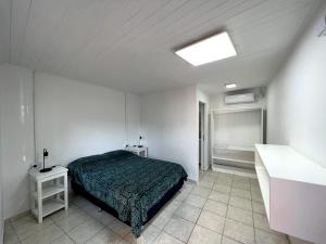 um quarto com uma cama num quarto branco em Steve's House em Puerto Iguazú