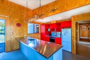 a kitchen with red cabinets and a counter top at Castle Hall - Lake Tekapo in Lake Tekapo