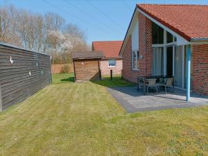 een huis met een patio met een tafel in de tuin bij Ferienhaus Maiglöckchen in Papenburg