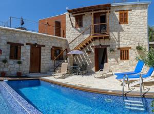 a villa with a swimming pool in front of a house at Stonehouse with private swimming pool in Paphos