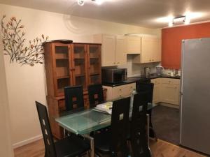 a kitchen with a table and chairs and a refrigerator at 2 bedroom Temsford Close Apartment in Harrow