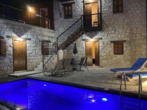 a house with a swimming pool with chairs and a staircase at Stonehouse with private swimming pool in Kallepia