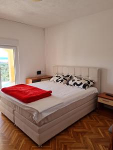 een slaapkamer met een groot wit bed en een rode deken bij Apartments Niki in Sveti Petar