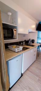 cocina con fregadero y microondas en Studio cosy avec parking, en Brest