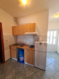 een keuken met een witte koelkast en een wastafel bij Apartments Niki in Sveti Petar