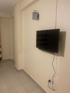 a flat screen tv hanging on a white wall at Magnolia guesthouse in Kampala +8 photos