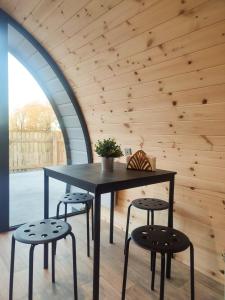 a dining room with a black table and two stools at Haven Pod Easkey in Sligo