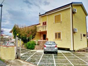 ein Auto, das auf einem Parkplatz vor einem Haus parkt in der Unterkunft Villa Elba in Praia a Mare