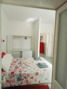 a bedroom with a bed with a floral bedspread at La casa di Alessandro in Monopoli