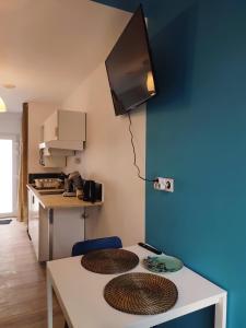 una pequeña cocina con mesa y 2 sillas en Studio cosy avec parking, en Brest