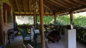 un porche cubierto con sillas y una persona durmiendo en él en Casa Rural Garro, en Guerricaiz