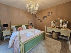 a bedroom with a bed with mirrors and a chandelier at Little Broad Cottage Norfolk 2 Bedroom Sleep 4 in Great Yarmouth