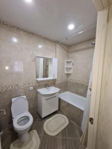 a bathroom with a toilet and a tub and a sink at New Аpartment Balti in Bălţi