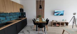 a kitchen with a table and chairs in a room at Marina Dziwnów Apartment in Dziwnów