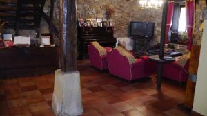 a living room with two purple chairs and a tv at Casa Rural Garro in Guerricaiz