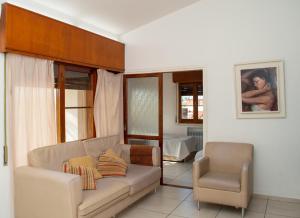 sala de estar con sofá y silla en Casa en centro de Carlos Paz con pileta en Villa Carlos Paz
