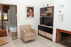 sala de estar con silla y TV en Casa en centro de Carlos Paz con pileta en Villa Carlos Paz