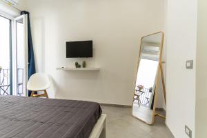 1 dormitorio con cama, espejo y TV en Nena Sweet Home, en Palermo